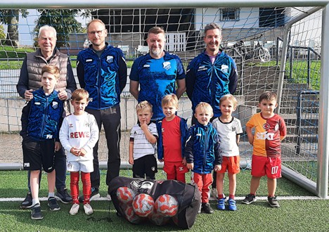 Mehrere Personen stehen vor einem Fußballtor