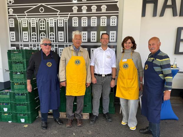 Mitglieder der Lions und der Marktleiter des Hit-Marktes stehen vor dem Markt und vor vollen Kisten mit gespendeten Lebensmmitteln